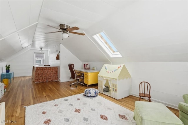 interior space with lofted ceiling with skylight and wood finished floors