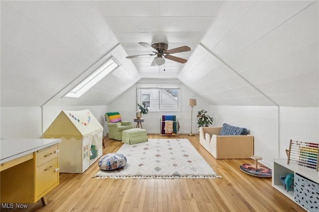 additional living space featuring lofted ceiling with skylight, light wood-type flooring, and ceiling fan