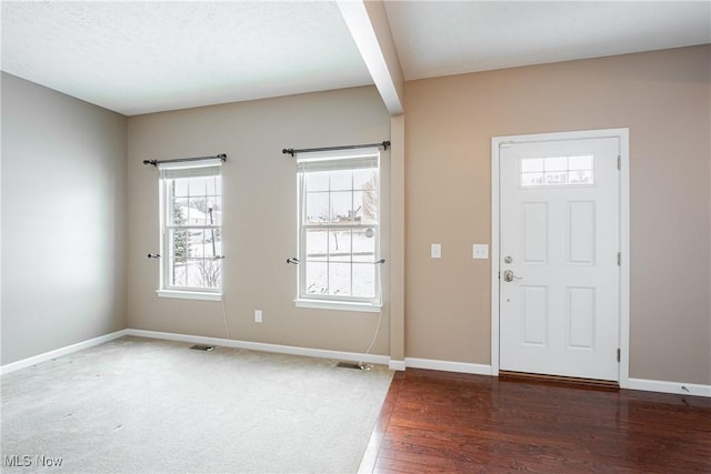 foyer with dark wood-style floors, visible vents, a textured ceiling, and baseboards