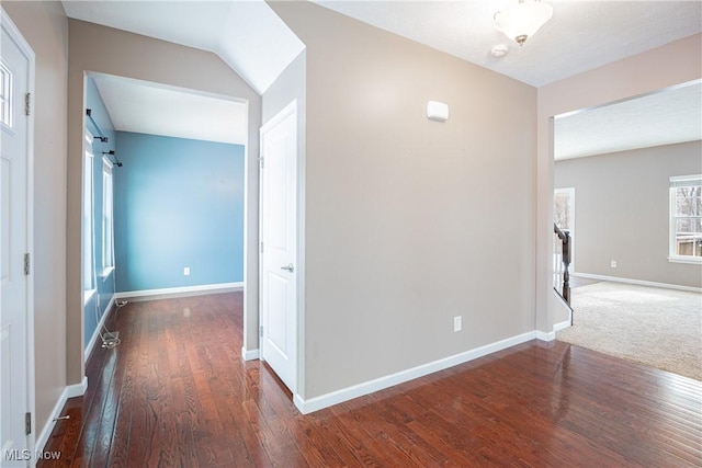 hallway with dark wood-style flooring and baseboards