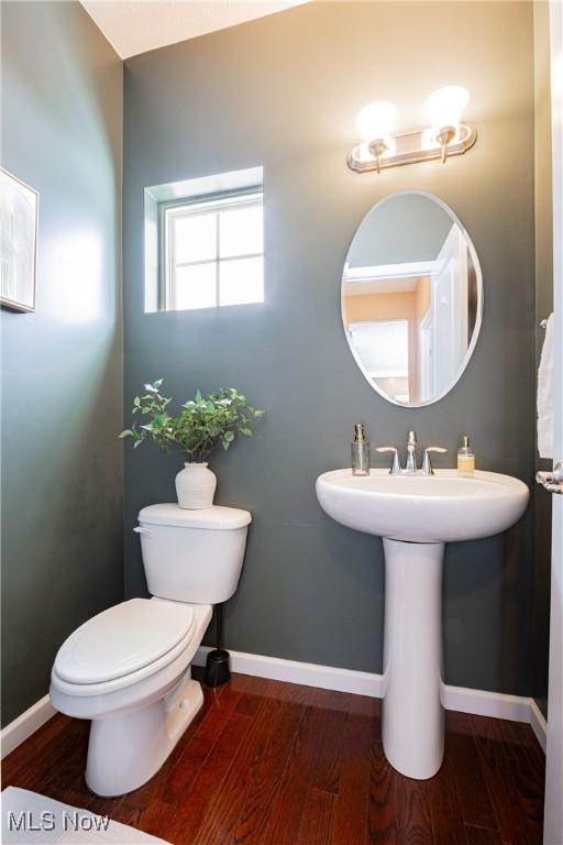 bathroom featuring wood finished floors, toilet, and baseboards