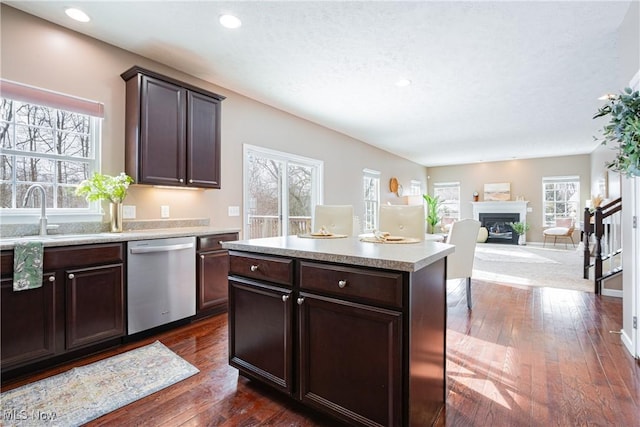 kitchen with light countertops, dishwasher, a sink, and dark brown cabinets