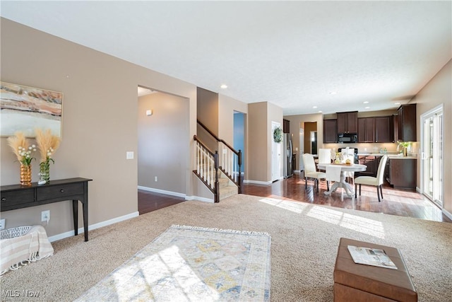 living area with dark colored carpet, stairway, recessed lighting, and baseboards