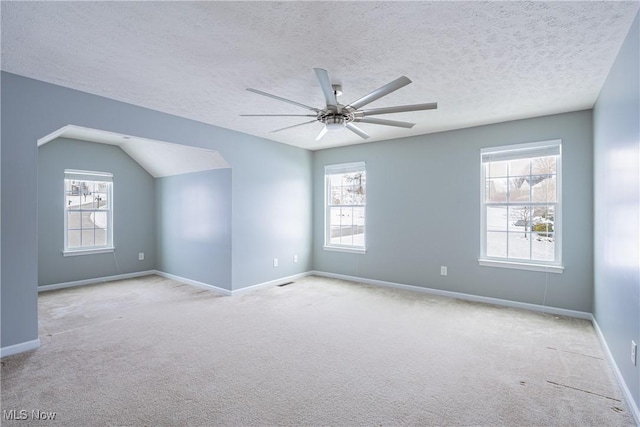 spare room featuring plenty of natural light, a ceiling fan, and light colored carpet