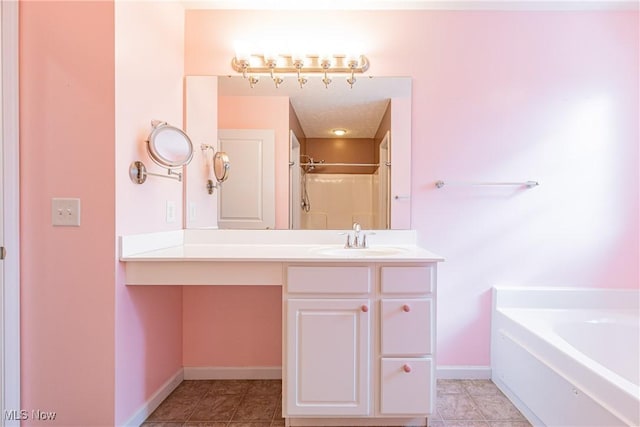 bathroom featuring a garden tub, vanity, tile patterned flooring, baseboards, and walk in shower