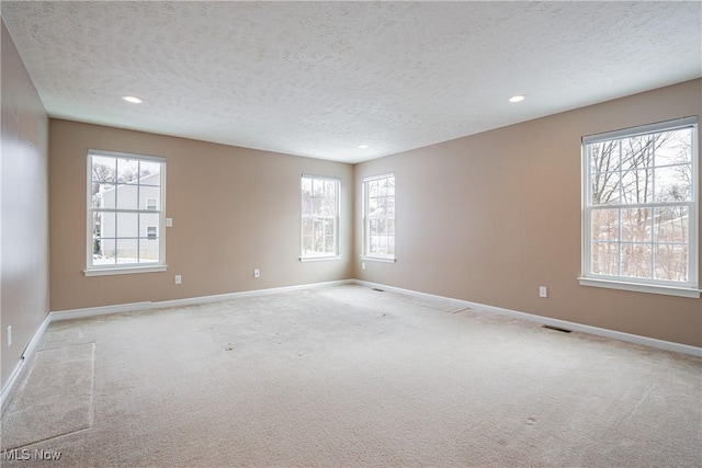 unfurnished room featuring recessed lighting, light colored carpet, visible vents, and baseboards