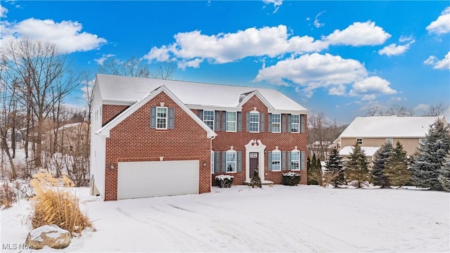 colonial home featuring a garage and brick siding