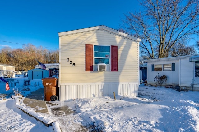 view of front facade featuring a shed, cooling unit, and an outbuilding