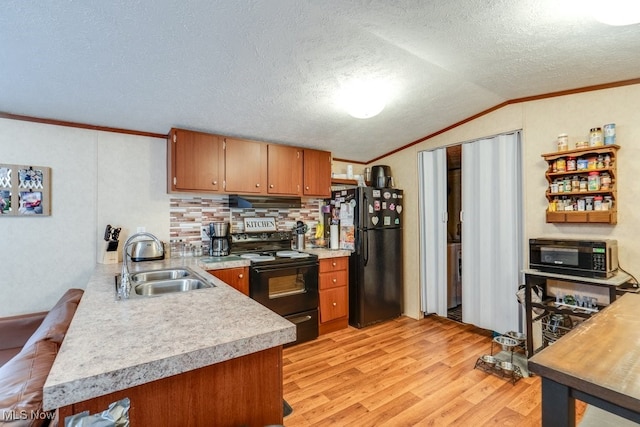 kitchen with brown cabinetry, lofted ceiling, light countertops, black appliances, and a sink