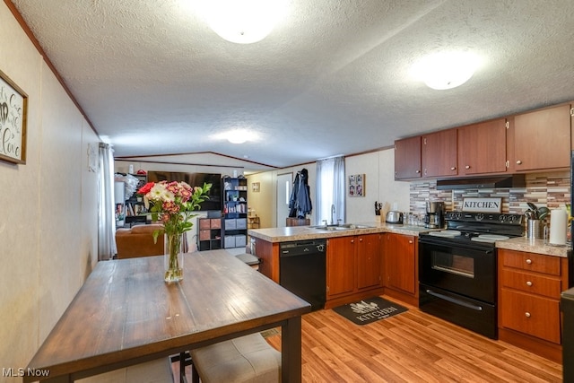 kitchen with light countertops, brown cabinetry, a sink, a peninsula, and black appliances