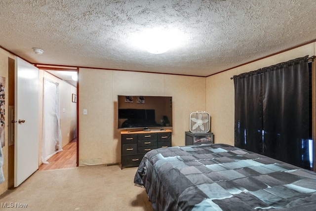 bedroom with a textured ceiling, light colored carpet, and crown molding