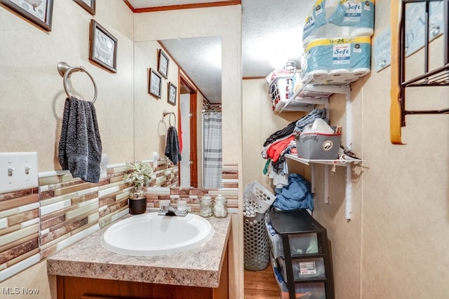 bathroom with crown molding, wood finished floors, and vanity