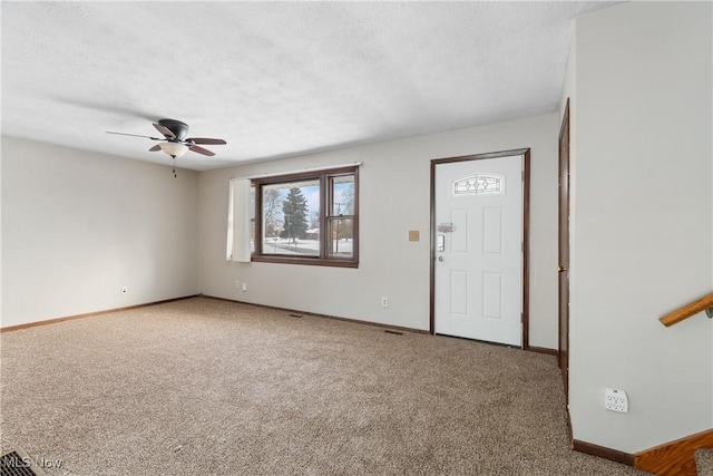 interior space featuring ceiling fan, a textured ceiling, and baseboards