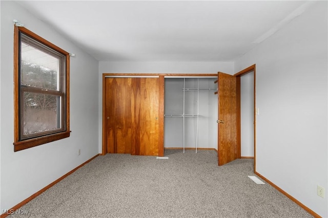 unfurnished bedroom featuring carpet, a closet, and baseboards