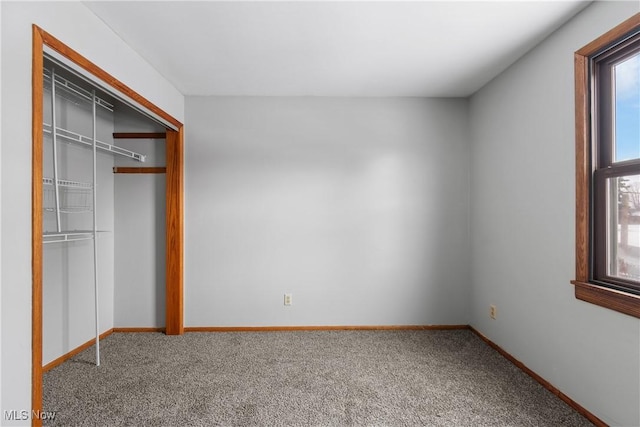 unfurnished bedroom featuring a closet, carpet flooring, and baseboards