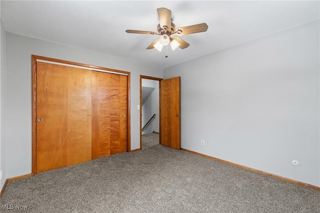 unfurnished bedroom with a closet, carpet flooring, ceiling fan, and baseboards