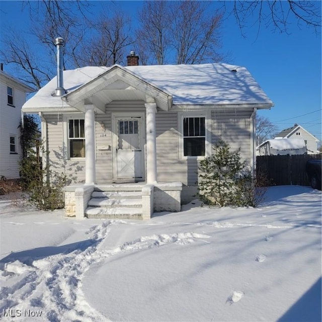 view of front of property featuring a chimney and fence