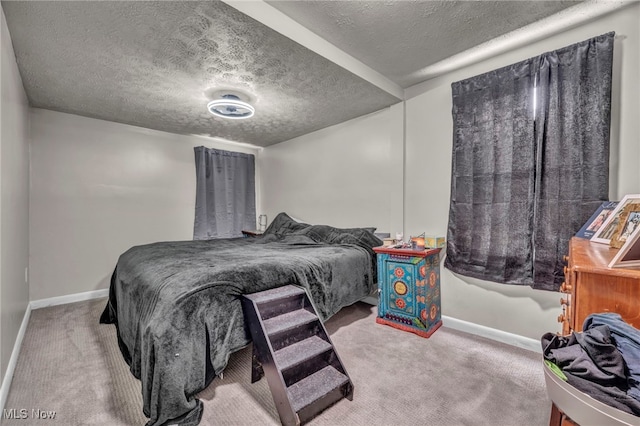 carpeted bedroom featuring a textured ceiling and baseboards