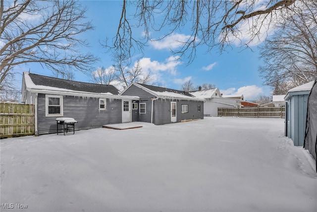 snow covered property featuring fence