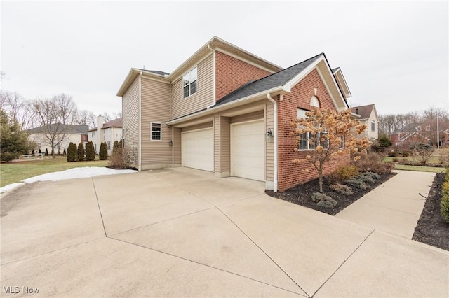 view of home's exterior with an attached garage, concrete driveway, and brick siding