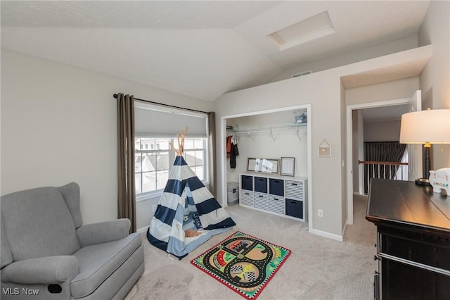 living area featuring attic access, visible vents, baseboards, light colored carpet, and lofted ceiling