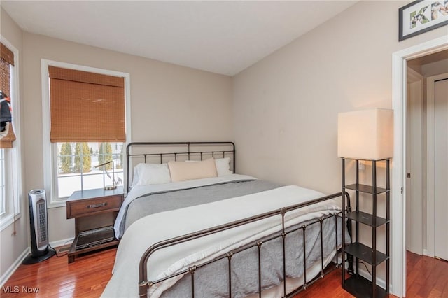 bedroom with baseboards and wood finished floors