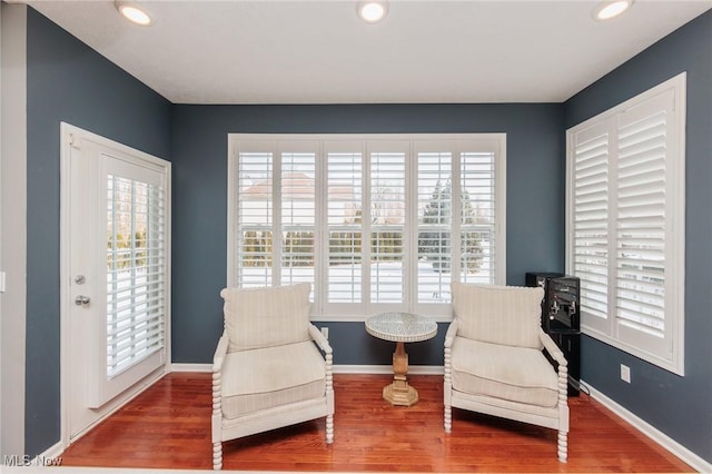 sitting room with baseboards, wood finished floors, and recessed lighting