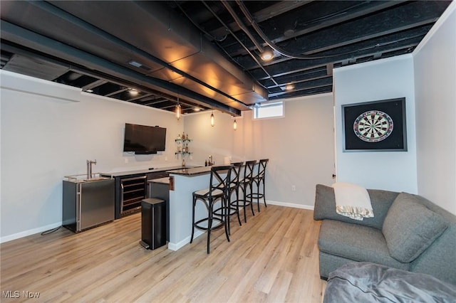 bar with wine cooler, visible vents, light wood-style flooring, baseboards, and fridge