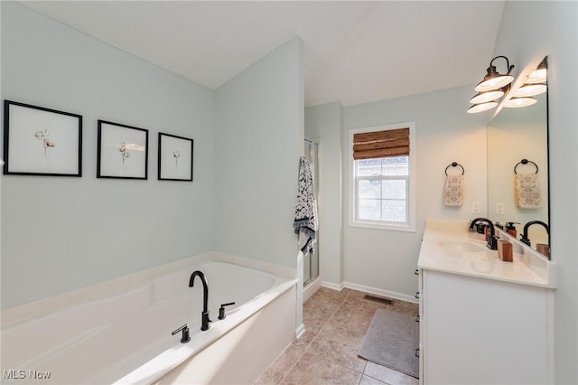 bathroom with vanity, visible vents, baseboards, a bath, and tile patterned floors