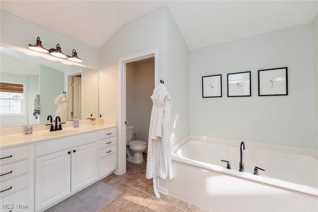 full bathroom with toilet, vanity, vaulted ceiling, a bath, and tile patterned floors