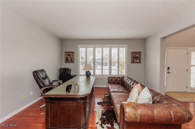 office space featuring baseboards and wood finished floors