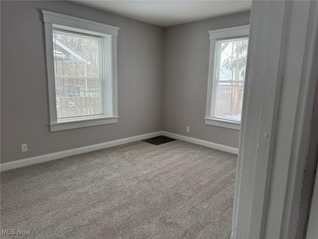 unfurnished room featuring carpet and baseboards