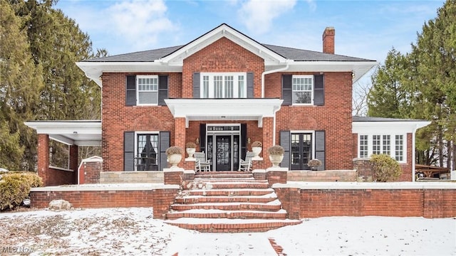 view of front of home with brick siding and a chimney