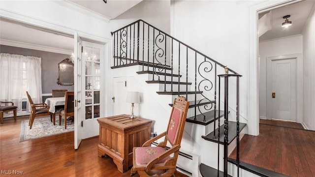 stairway with french doors, ornamental molding, and wood finished floors