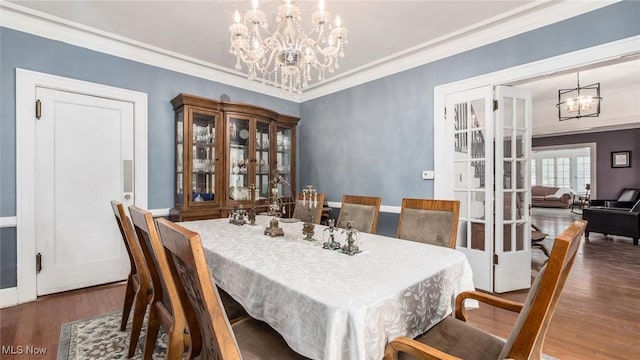 dining area featuring a chandelier, dark wood-type flooring, and crown molding