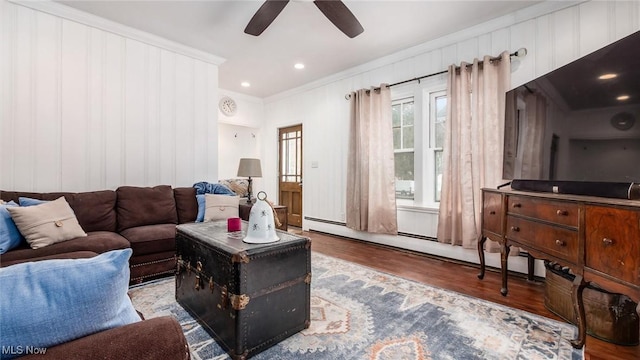 living room with crown molding, light wood finished floors, recessed lighting, baseboard heating, and a ceiling fan