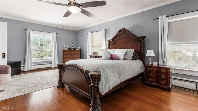 bedroom featuring ornamental molding, a baseboard heating unit, ceiling fan, and wood finished floors