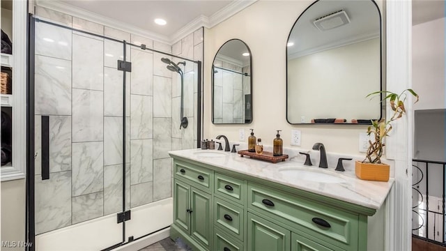 full bathroom featuring double vanity, a shower stall, ornamental molding, and a sink