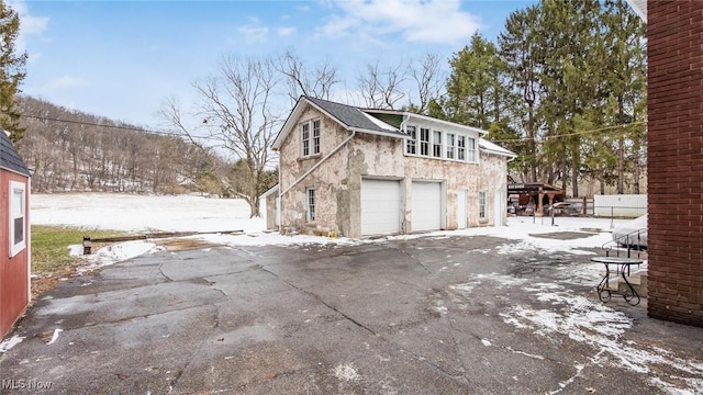 snow covered property with an attached garage