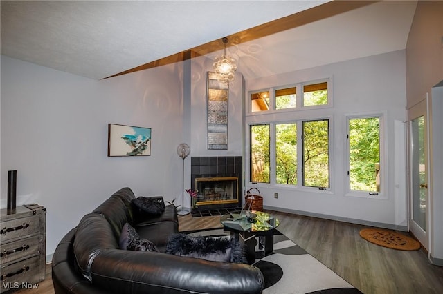 living room with lofted ceiling, a fireplace, baseboards, and wood finished floors