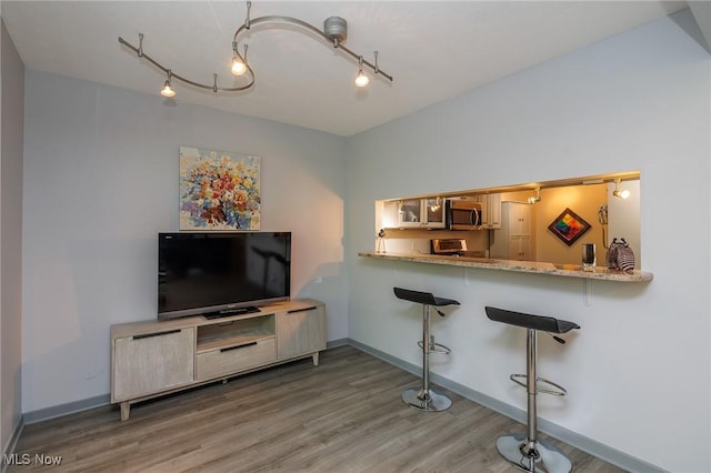 interior space with track lighting, baseboards, and wood finished floors