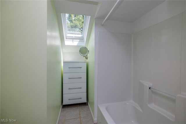 full bath featuring a skylight, tile patterned flooring, and baseboards