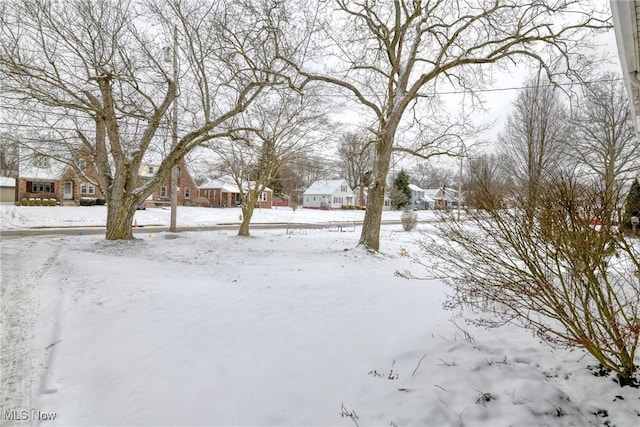 yard layered in snow featuring a residential view