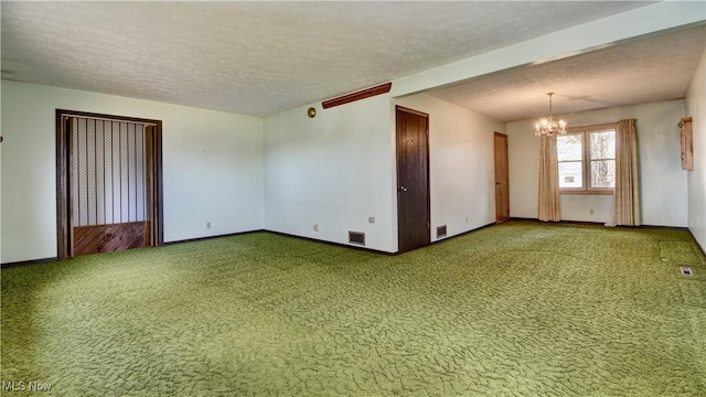 carpeted spare room featuring baseboards, a textured ceiling, visible vents, and a notable chandelier