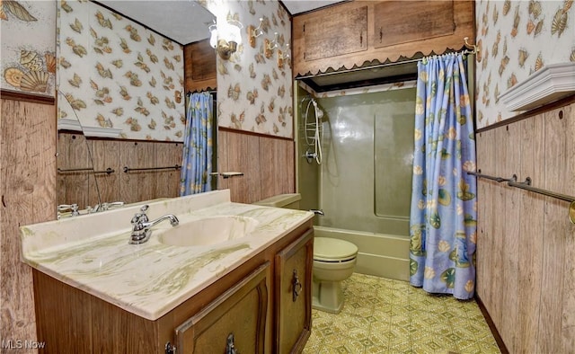 full bathroom featuring wallpapered walls, toilet, a wainscoted wall, shower / tub combo with curtain, and tile patterned floors