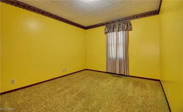 carpeted spare room featuring visible vents, baseboards, and a textured ceiling