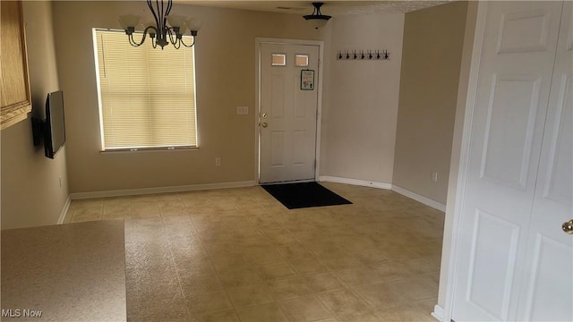 interior space with a chandelier and baseboards