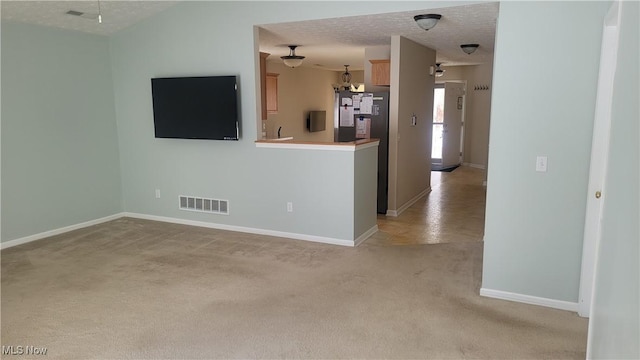 kitchen featuring light carpet, baseboards, visible vents, light countertops, and a textured ceiling