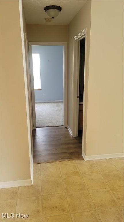 hallway featuring baseboards