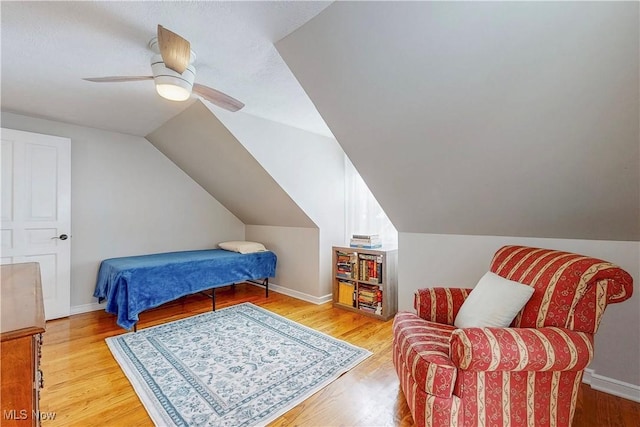 bedroom with light wood-type flooring, ceiling fan, baseboards, and lofted ceiling